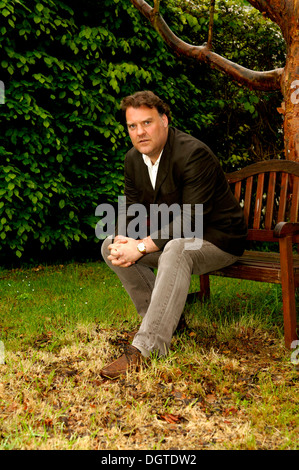 Bryn Terfel JONES CBE, le chanteur d'opéra baryton basse gallois assis sur un banc sous un arbre. Banque D'Images