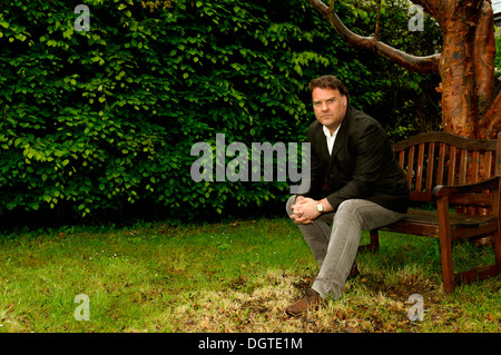 Bryn Terfel JONES CBE, le chanteur d'opéra baryton basse gallois assis sur un banc sous un arbre.l Banque D'Images