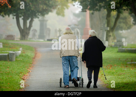 Couple de personnes âgées sentier de marche à travers le cimetière de Ross Bay autumn mist - Victoria, Colombie-Britannique, Canada. Banque D'Images