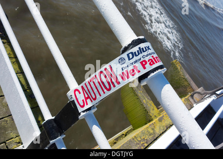 Panneau d'avertissement de scotch Attention travaux de peinture humide de repeindre les rambardes sur Saltburn Pier Banque D'Images