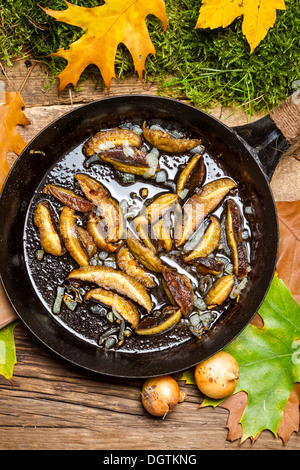 Oignons frais et les champignons dans une casserole Banque D'Images