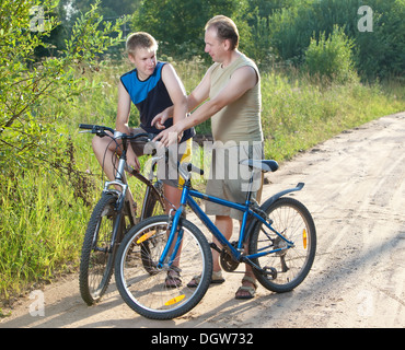 Le père avec le fils sur les bicyclettes Banque D'Images