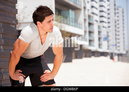 L'homme de l'athlète fatigué après une longue marche dans la ville d'événements sportifs. Banque D'Images