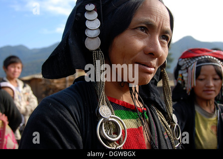Portrait, femme de l'ethnie Akha Phixor, vêtements traditionnels teints à l'indigo, avec une coiffure de pièces d'argent Banque D'Images