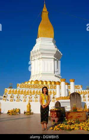 Le laotien femme debout en face d'un grand stupa en blanc et or, jupe, nas, Pha Si Kotabong, Tha Khek Banque D'Images