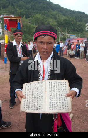 Festival ethnique, l'homme de la minorité Yao en costume traditionnel Présentation de livre et écrit, Golden Dome International, la ville de Pu'er Banque D'Images