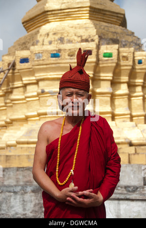 Le bouddhisme Theravada, stupa doré, moine en robe rouge et le chapeau, que Xieng Tung, Muang Sing, Province de Luang Namtha, Sipsongpanna Banque D'Images