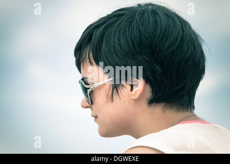 Profil de la jeune femme en face de lunettes de ciel. Banque D'Images