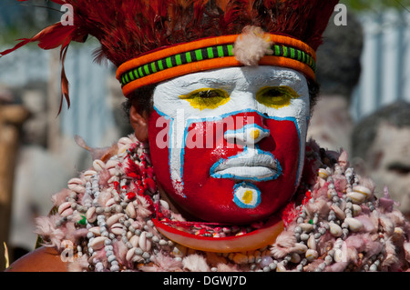 Membre d'une tribu dans un costume à la décoration colorée avec la peinture pour le visage à la traditionnelle collecte sing-sing, Hochland Banque D'Images
