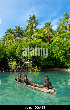 Les garçons locaux dans un canot dans le lagon de Marovo Lagon de Marovo,, Province de l'Ouest, les Îles Salomon Banque D'Images