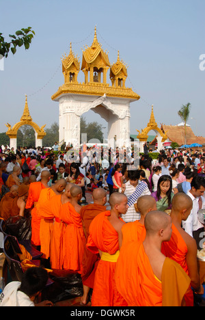 Le bouddhisme Theravada, That Luang Festival, Tak Bat, les croyants, les pèlerins l'aumône, les moines se tenant ensemble, robes orange Banque D'Images