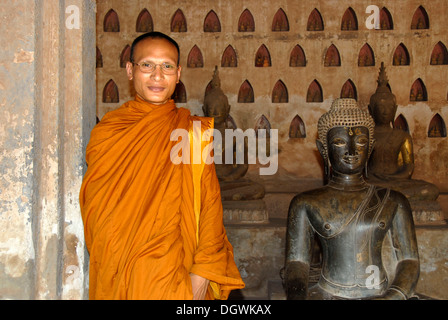 Le bouddhisme Theravada, moine vêtu de robes orange, ancienne statue de Bouddha en bronze, Wat Sisaket, Vientiane, Laos, Asie du Sud, Asie Banque D'Images