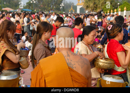 Le bouddhisme Theravada, That Luang Festival, Tak Bat, tatouages, moine avec tatouages spirituelle sur son dos et en tête à tête, les croyants Banque D'Images