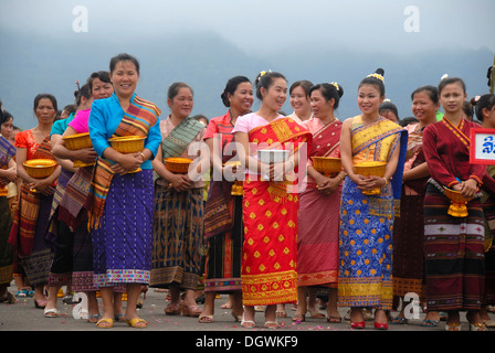 Festival, les femmes de l'ethnie Lao Loum avec bols sacrificiels, des vêtements traditionnels colorés, longue jupe, sin, Muang Xai Banque D'Images