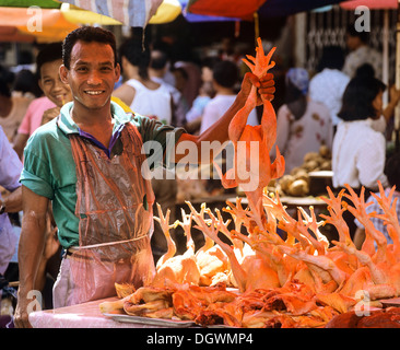 Homme tenant un poulet dans un marché à Kuching, Sarawak, Malaisie Banque D'Images