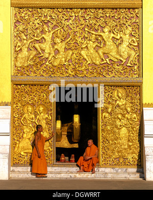 Reliefs d'or, les moines à l'entrée de la maison de transport et Wat Xieng Tong ou TVA Xienthong, Luang Prabang Banque D'Images