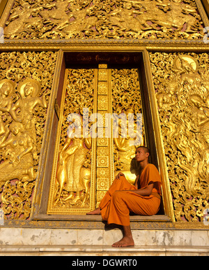 Reliefs d'or, moine à l'entrée de la maison de transport et Wat Xieng Tong ou TVA Xienthong, Luang Prabang Banque D'Images