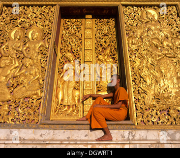 Reliefs d'or, moine à l'entrée de la maison de transport et Wat Xieng Tong ou TVA Xienthong, Luang Prabang Banque D'Images