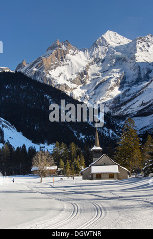 Paysage d'hiver avec les skieurs de fond, Blueemlisalp massif au milieu, Eglise St Mary, Alpes Bernoises, Kandersteg Banque D'Images