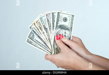 Poignée de dollars bills américains se déploient en éventail dans a woman's hand Banque D'Images