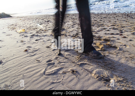 Pieds de l'homme de cultiver la marche nordique sur la plage Banque D'Images