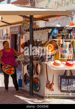 Un exposant met la dernière main à son stand de souvenirs dans le centre de Cabo San Lucas, Baja California Sur, Mexique Banque D'Images