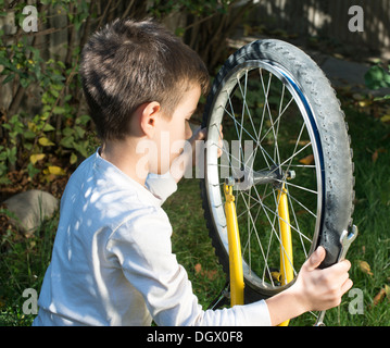 Enfant qui fixez les vélos. Garçon et location Banque D'Images