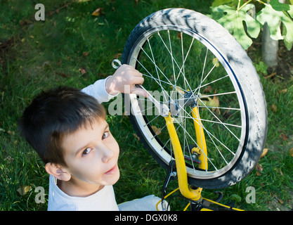 Enfant qui fixez les vélos. Garçon et location Banque D'Images