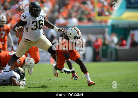 Miami, FL, USA. 26Th Oct, 2013. Dallas Crawford # 25 de Miami se précipite hors de Tylor Harris # 36 de service durant le NCAA football match entre le service et les diacres de démon Forêt Miami Gardens, en Floride. Les Hurricanes a battu le démon diacres 24-21. © Cal Sport Media/Alamy Live News Banque D'Images