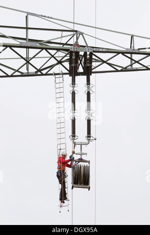 Poseur de travailler avec un câble métallique de levage sur un 380-kV ligne longue distance administré par l'opérateur du système de transmission 50Hertz, voie Banque D'Images