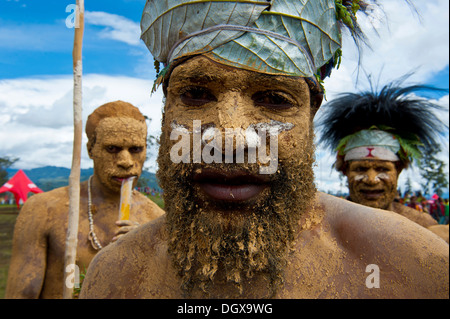 Membre d'une tribu dans un costume à la décoration colorée avec la peinture du visage et du corps à la traditionnelle collecte sing-sing, Hochland Banque D'Images