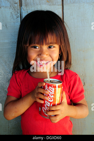 Rire petite fille boire d'une Coca Cola peut dans une paille, au Cambodge, en Asie du Sud-Est, l'Asie Banque D'Images