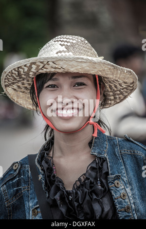 A smiling Asian girl avec chapeau de paille traditionnelle cambodgienne. Le Cambodge en Asie du sud-est. Asian woman smiling Banque D'Images