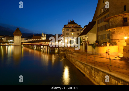 Les lumières de pont de la chapelle et de la tour de l'eau se reflètent dans l'eau de la rivière Reuss, à Lucerne, Suisse, Europe Banque D'Images
