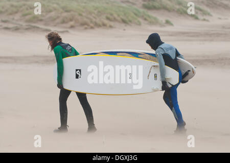 Coney Beach, Porthcawl, UK. 27 octobre 2013. Deux jeunes surfeurs dans une tempête de lutte contre les vents forts. Le littoral du sud du Pays de Galles est frappé par une forte à force de coup de vent associés à la dépression centrée sur le nord-ouest de l'Irlande que les météorologues prévisions des vents violents d'apporter pour le sud de l'Angleterre et au Pays de Galles dans la nuit de dimanche à lundi et peut provoquer des dégâts similaires à ceux le 15 octobre 1987. Crédit photo : Graham M. Lawrence/Alamy Live News. Banque D'Images