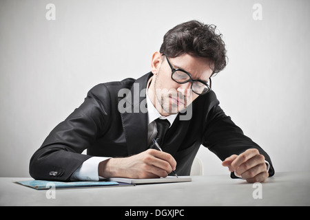 Les jeunes avec des lunettes d'affaires écrit sur un PC portable. Banque D'Images