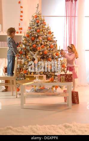 Girl and boy decorating a Christmas Tree Banque D'Images