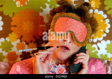 Vieille dame avec bandeau de sommeil et la cigarette avec un porteur, au look rétro coloré Banque D'Images