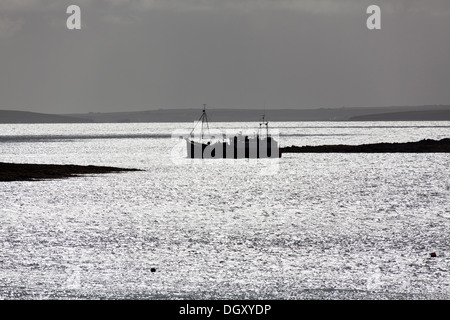 Des îles Orcades, en Écosse. La silhouette pittoresque vue sur un ferry le Houton ferry terminal dans la baie de Houton. Banque D'Images