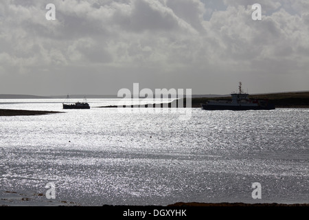 Des îles Orcades, en Écosse. La silhouette pittoresque vue de ferries de quitter le terminal de ferries de Houton dans la baie de Houton. Banque D'Images