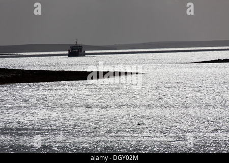 Des îles Orcades, en Écosse. La silhouette pittoresque vue sur un ferry le Houton ferry terminal dans la baie de Houton. Banque D'Images