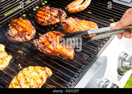 Steaks de porc sur un grill à gaz, Allemagne Banque D'Images