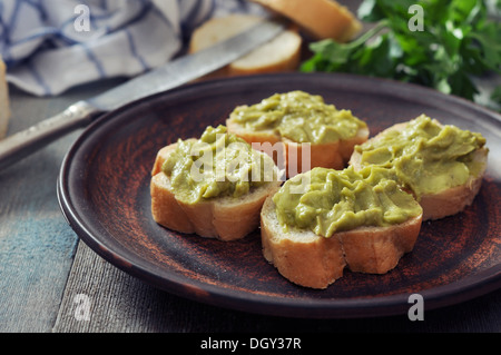 Délicieux apéritif canapés de pain et le guacamole servi avec du persil closeup Banque D'Images