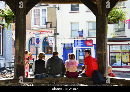 Adolescents assis sur la croix du marché, Market Place, North Walsham, Norfolk, Angleterre, Royaume-Uni Banque D'Images