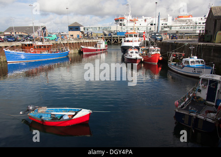 Des îles Orcades, en Écosse. Bateaux amarrés à Stromness's Harbour, avec le terminal des ferries en arrière-plan. Banque D'Images