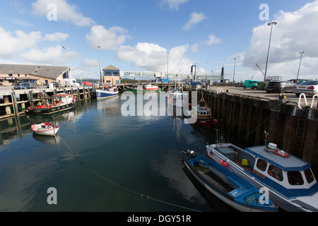 Des îles Orcades, en Écosse. Bateaux amarrés à Stromness's Harbour, avec le terminal des ferries en arrière-plan. Banque D'Images