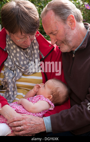 Les grands-parents holding et de câlins leur petite-fille Banque D'Images