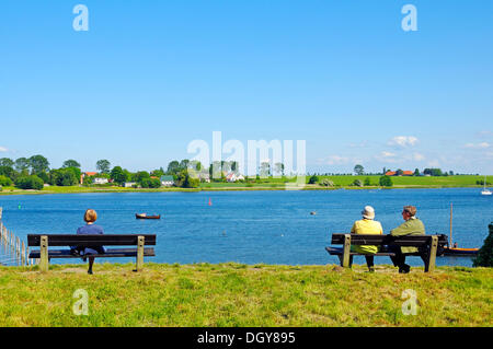 Personnes sur un banc à l'ensemble de l'estuaire à Kirchdorf, l'île de Poel, Mecklembourg-Poméranie-Occidentale Banque D'Images