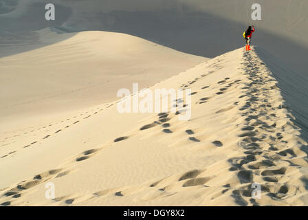 Jeune femme chinoise debout sur les dunes de sable du désert de Gobi photographiant le Crescent Lake avec la Pagode Chinoise Banque D'Images