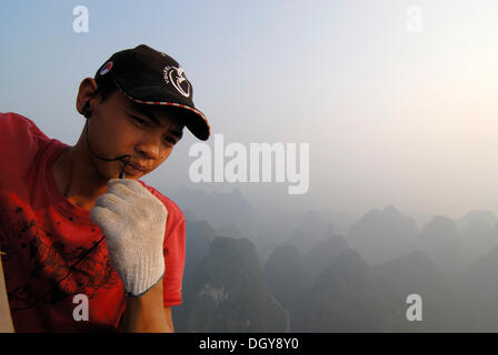 Balloonist dans un ballon à air chaud au-dessus du paysage karstique rocheux près de Yangshuo, Guilin, Guangxi, China, Asia Banque D'Images